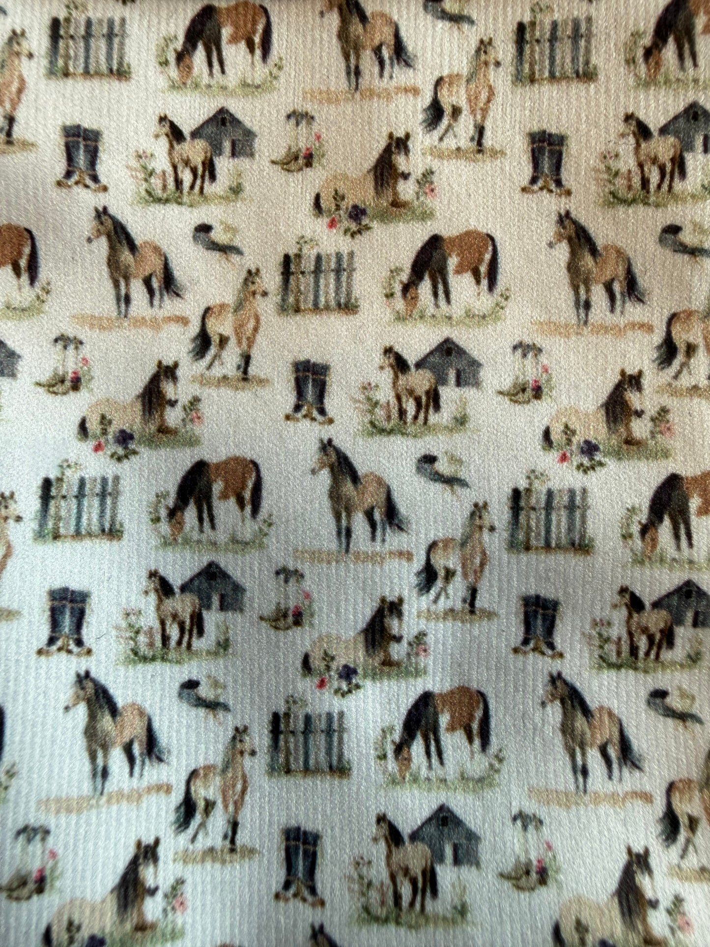Pattern of horses, boots, and fences on a beige background