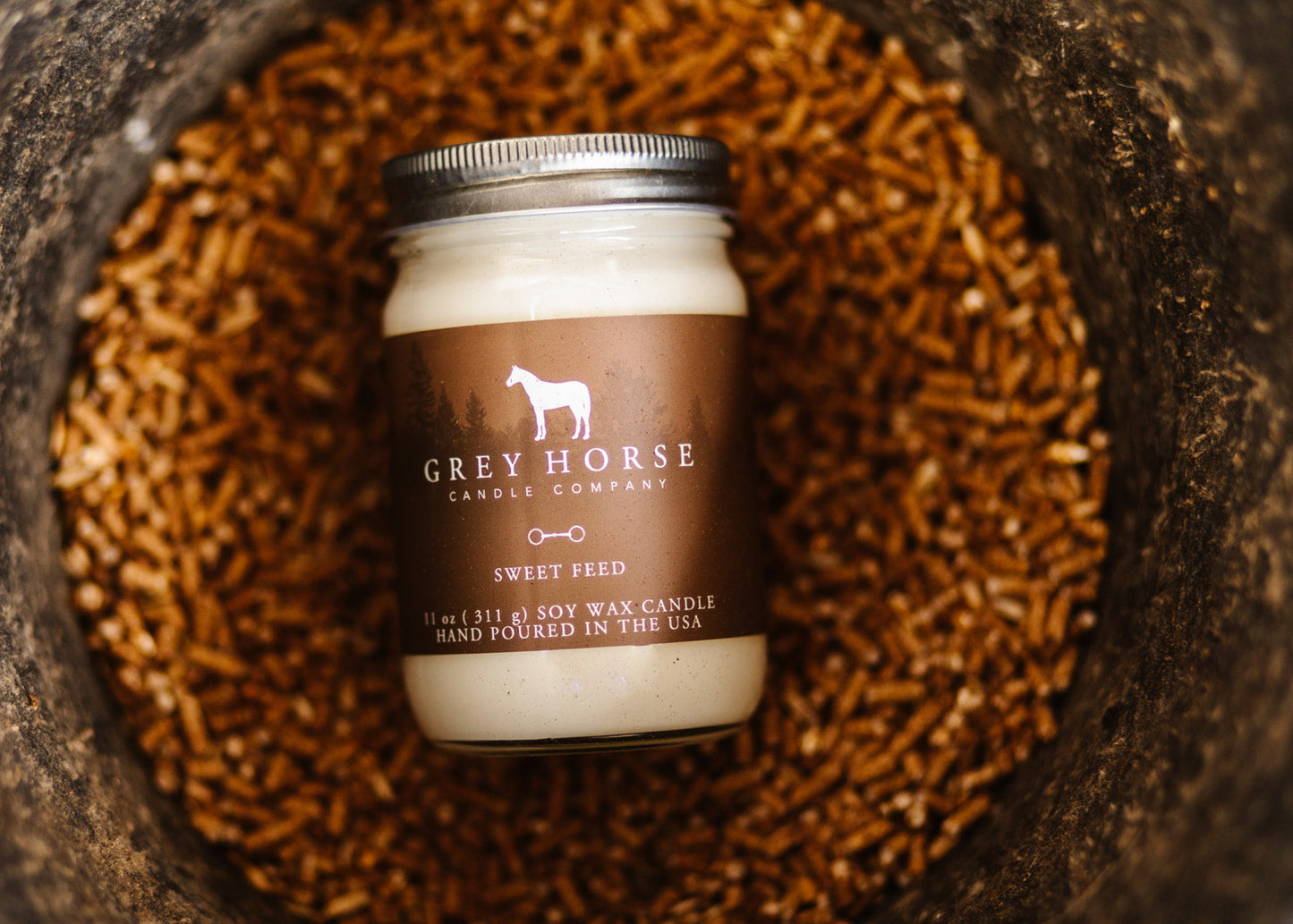 Candle jar with 'Grey Horse Candle Company' label on a wooden surface