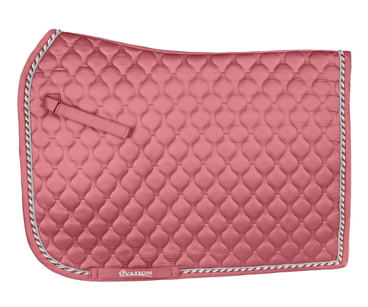 Pink quilted saddle pad with a bow on a white background