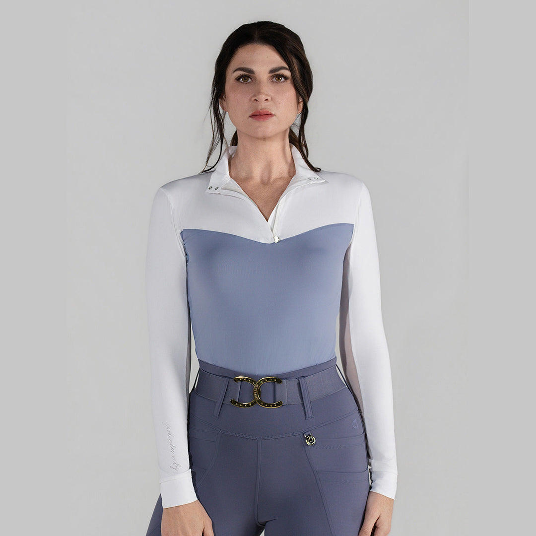 Woman wearing a two-tone equestrian shirt with a white and blue design on a gray background
