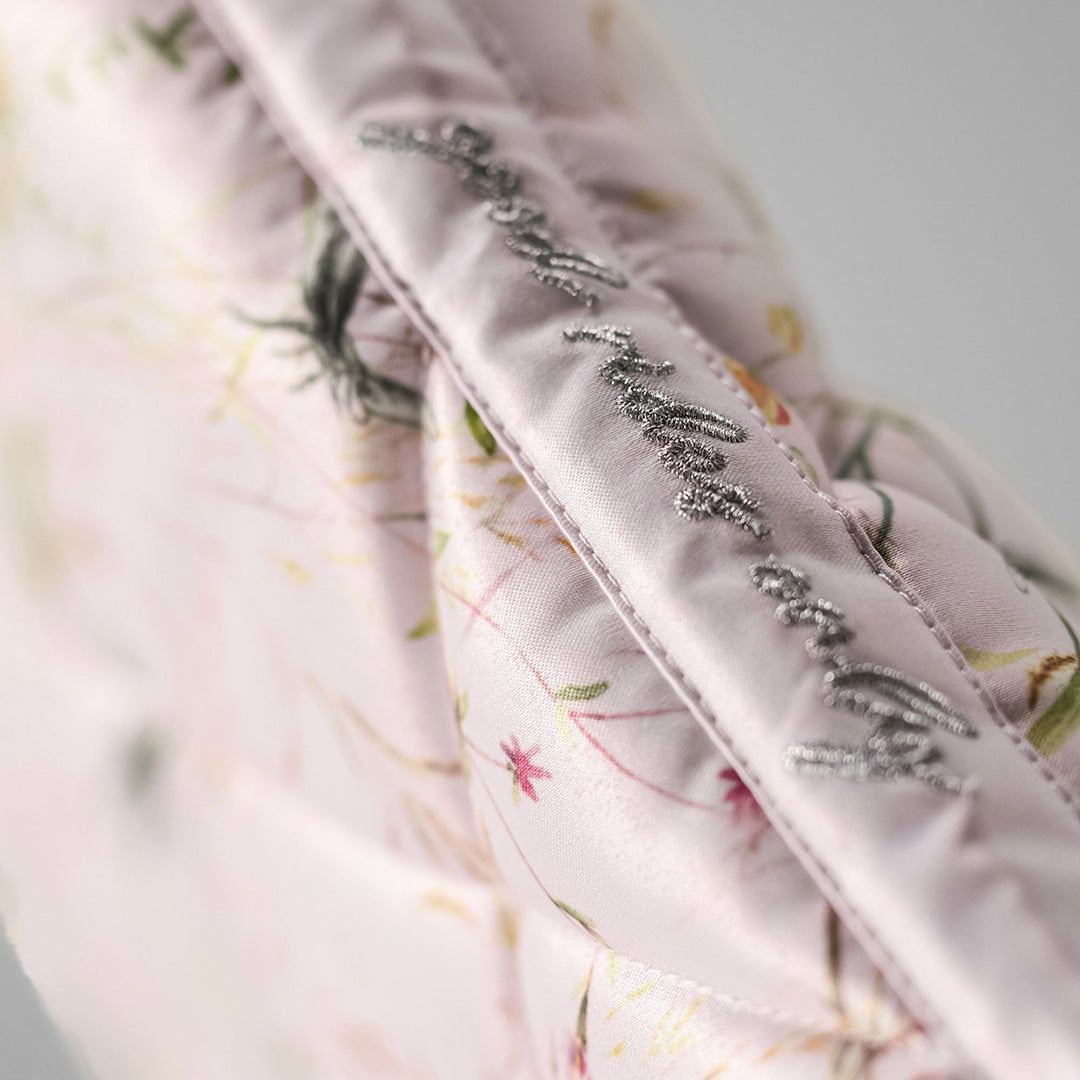 Close-up of a floral-patterned fabric with embroidered text on a light background
