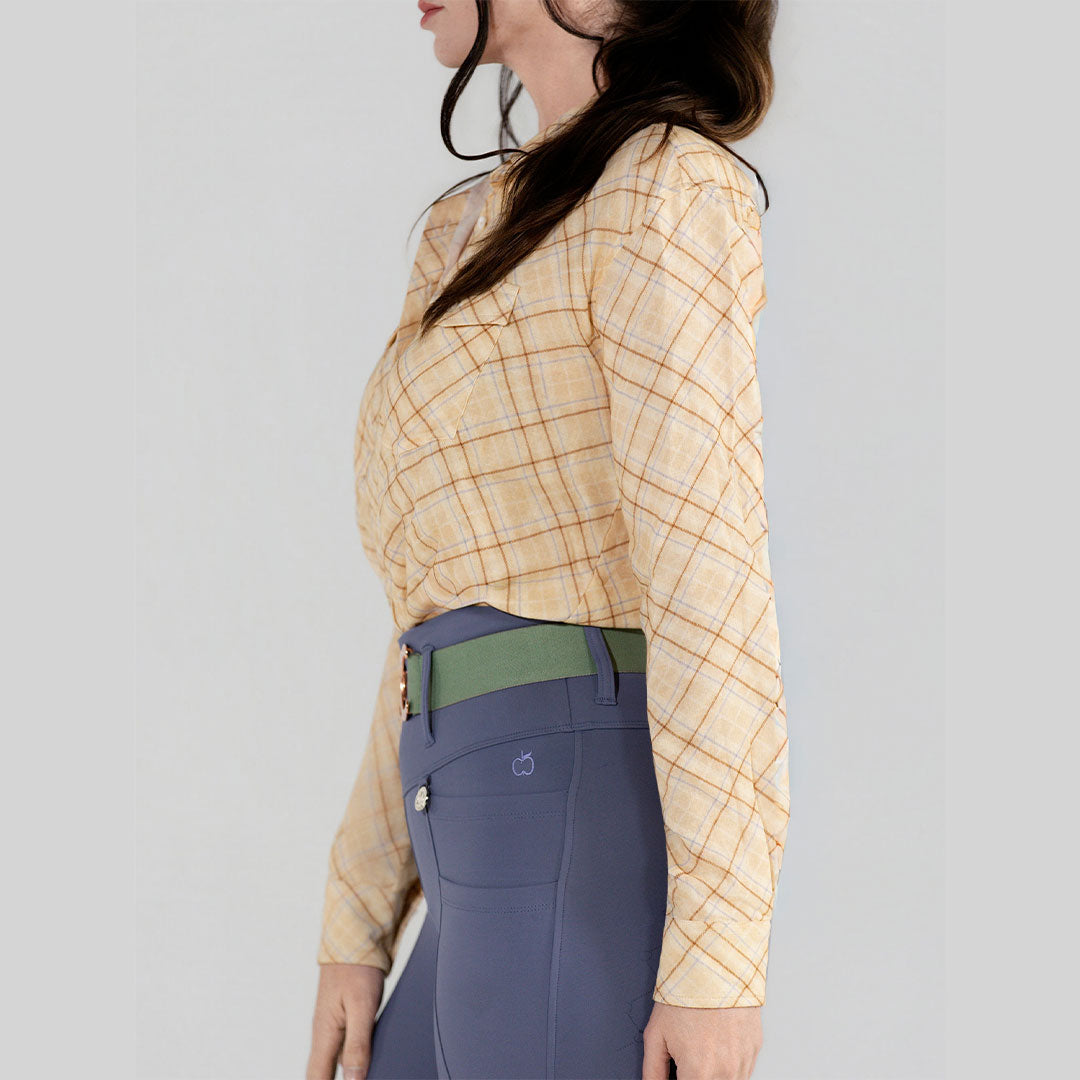 Woman wearing a yellow plaid shirt and blue pants on a gray background