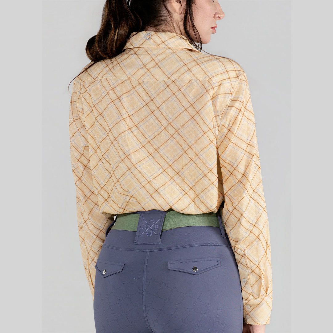 Person wearing a yellow plaid shirt and blue pants on a gray background