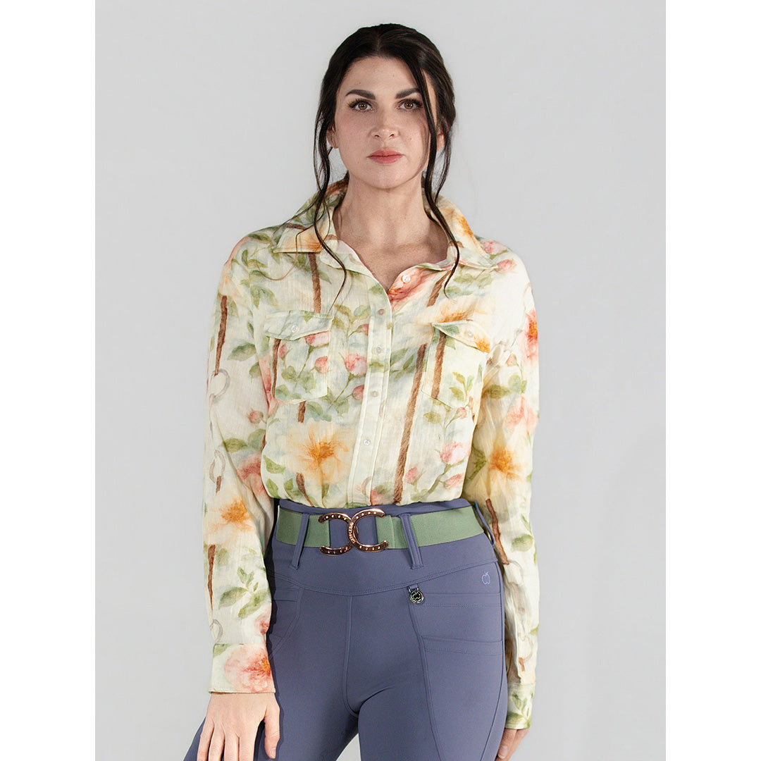 Woman wearing a floral blouse and purple pants on a gray background