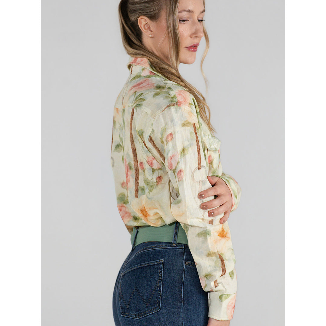 Woman wearing a floral blouse and jeans on a gray background
