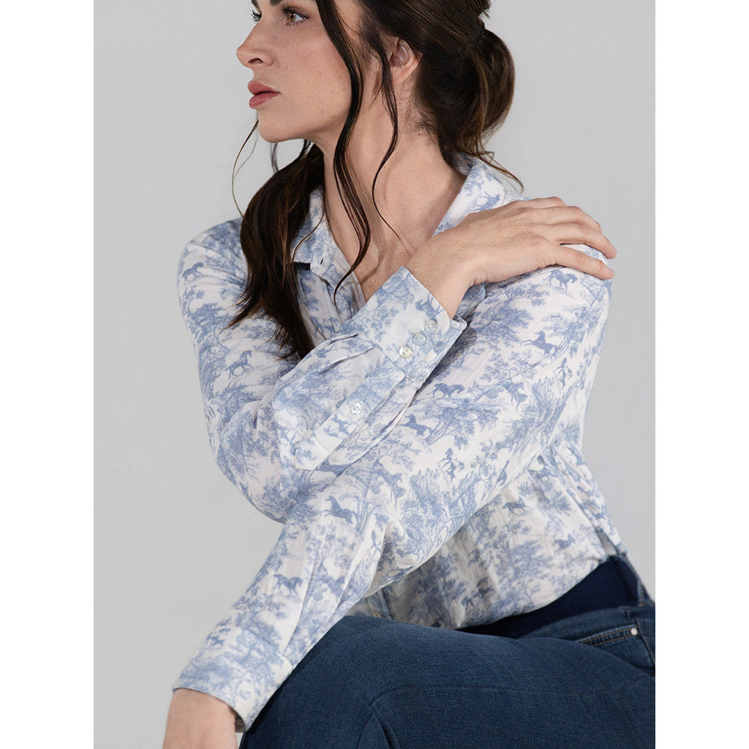 Woman wearing a light blue floral blouse against a gray background