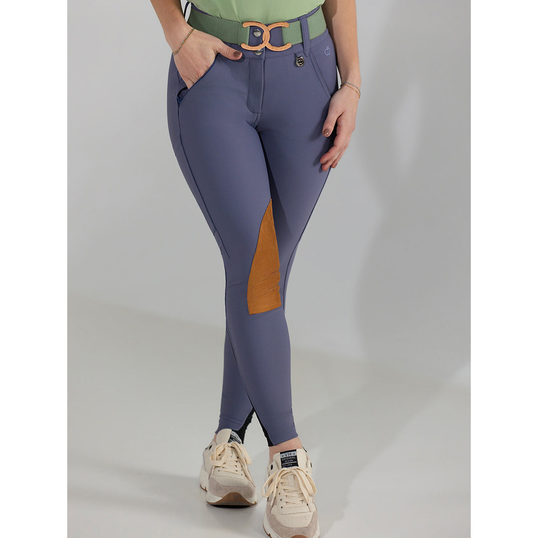 Person wearing purple riding pants with a brown patch on a gray background