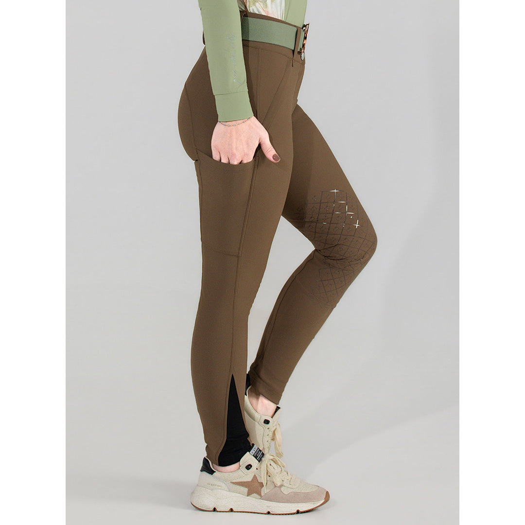 Brown riding pants worn by a person on a gray background