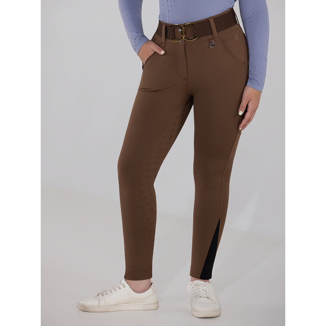 Brown riding pants with a black patch worn by a person on a gray background