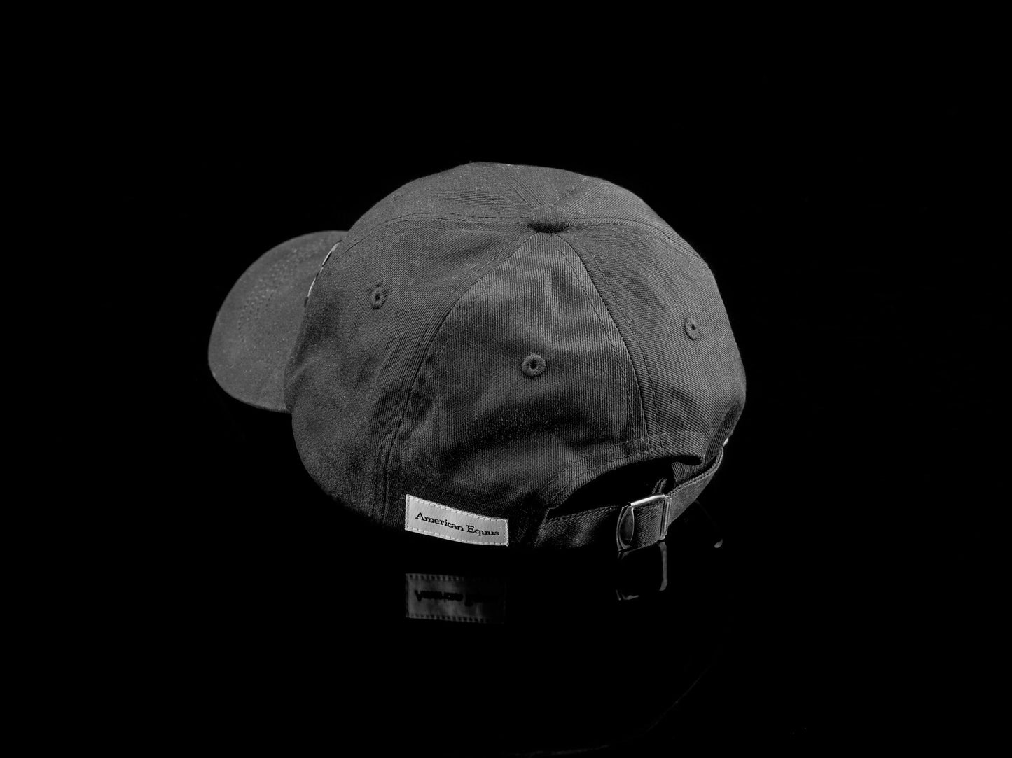 Dark gray cap with a brand label on a black background