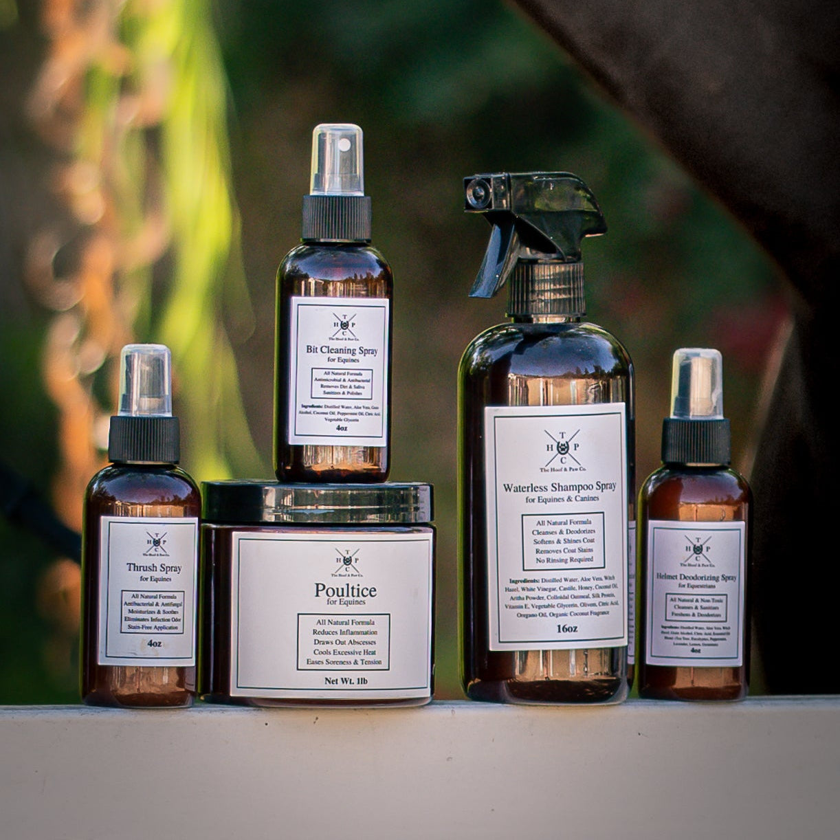 Collection of natural skincare products with labels on a blurred outdoor background