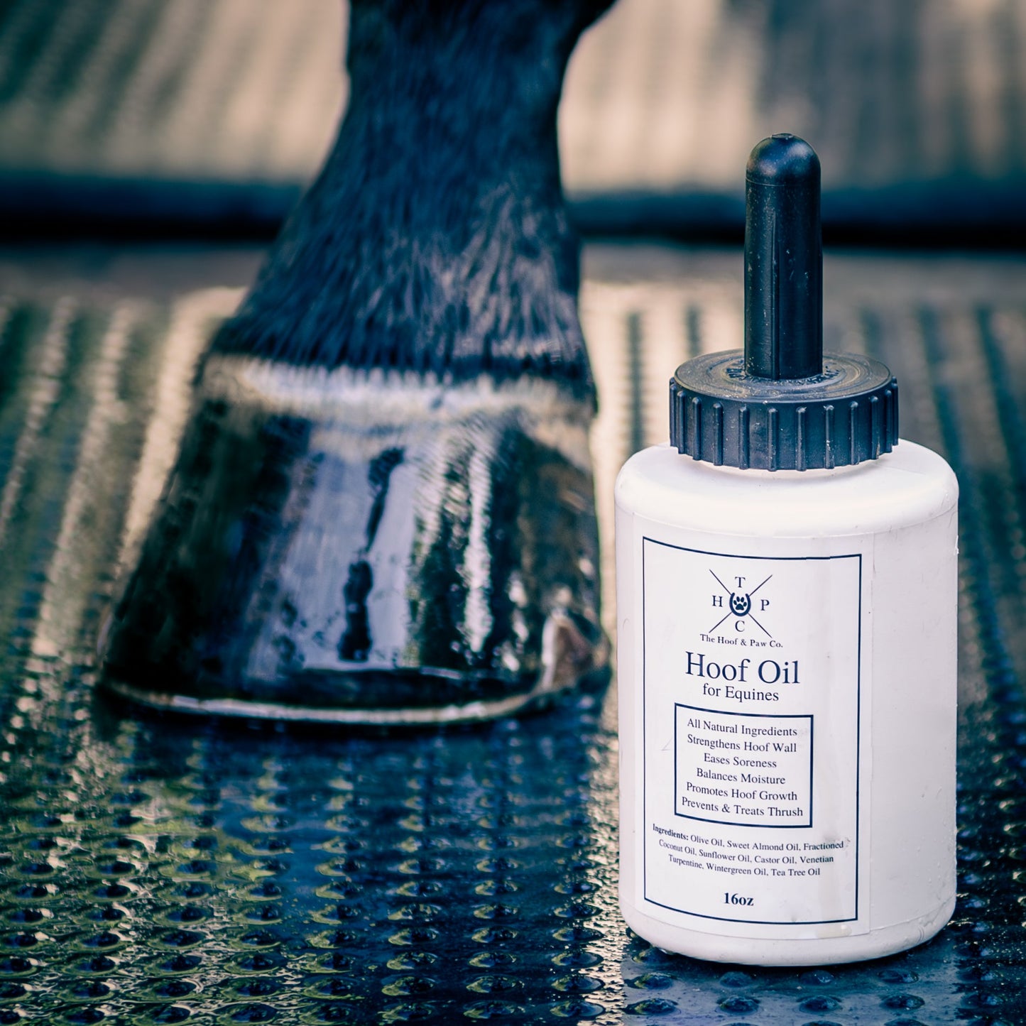 Bottle of hoof oil for equines on a reflective surface with a horse's hoof in the background.