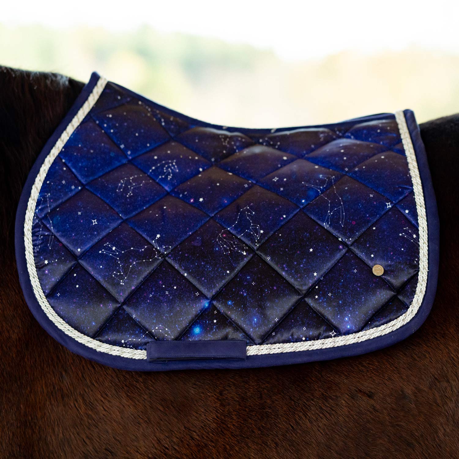 Blue quilted saddle pad with star pattern on a horse.