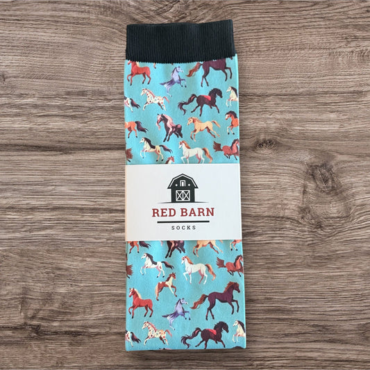 Pack of socks with horse pattern and 'Red Barn Socks' branding on a wooden surface