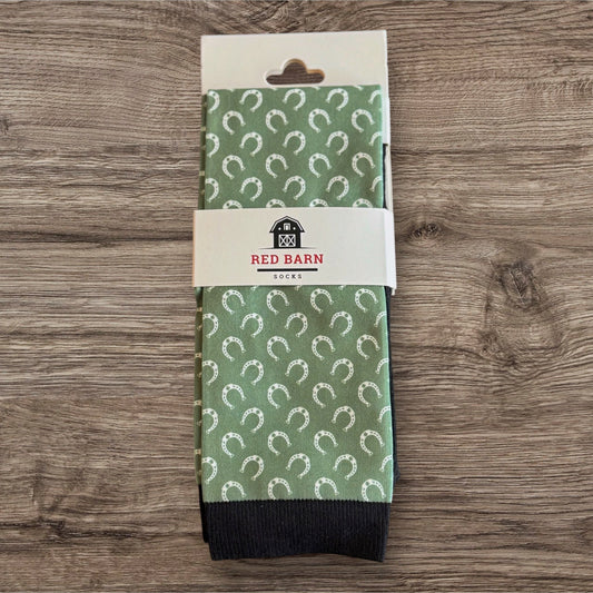 Green patterned socks with a 'Red Barn' label on a wooden surface