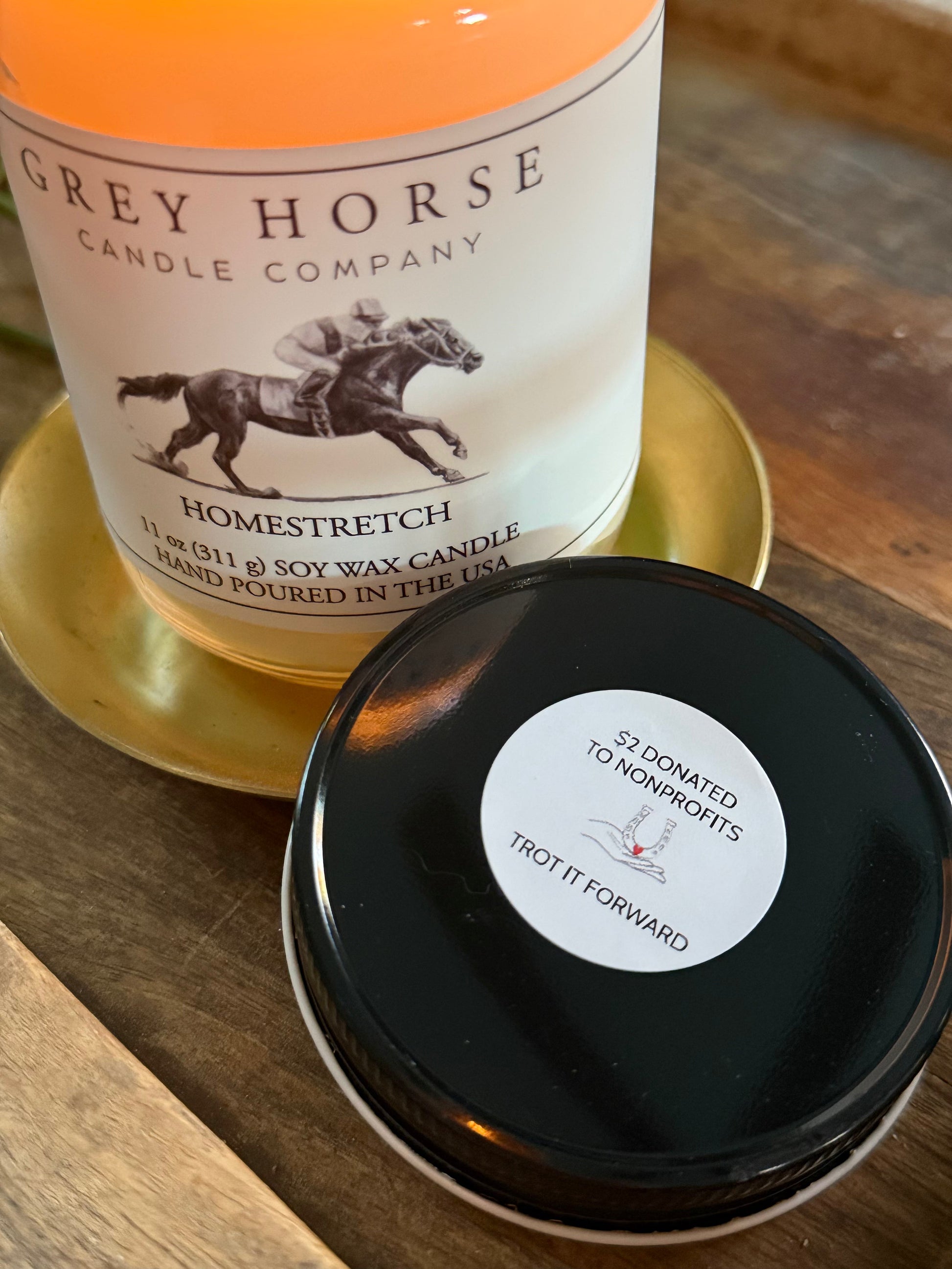 Candle with 'Grey Horse Candle Company' label and black lid on a wooden surface