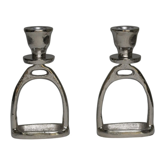 Two metallic candle holders shaped like horse stirrups on a white background