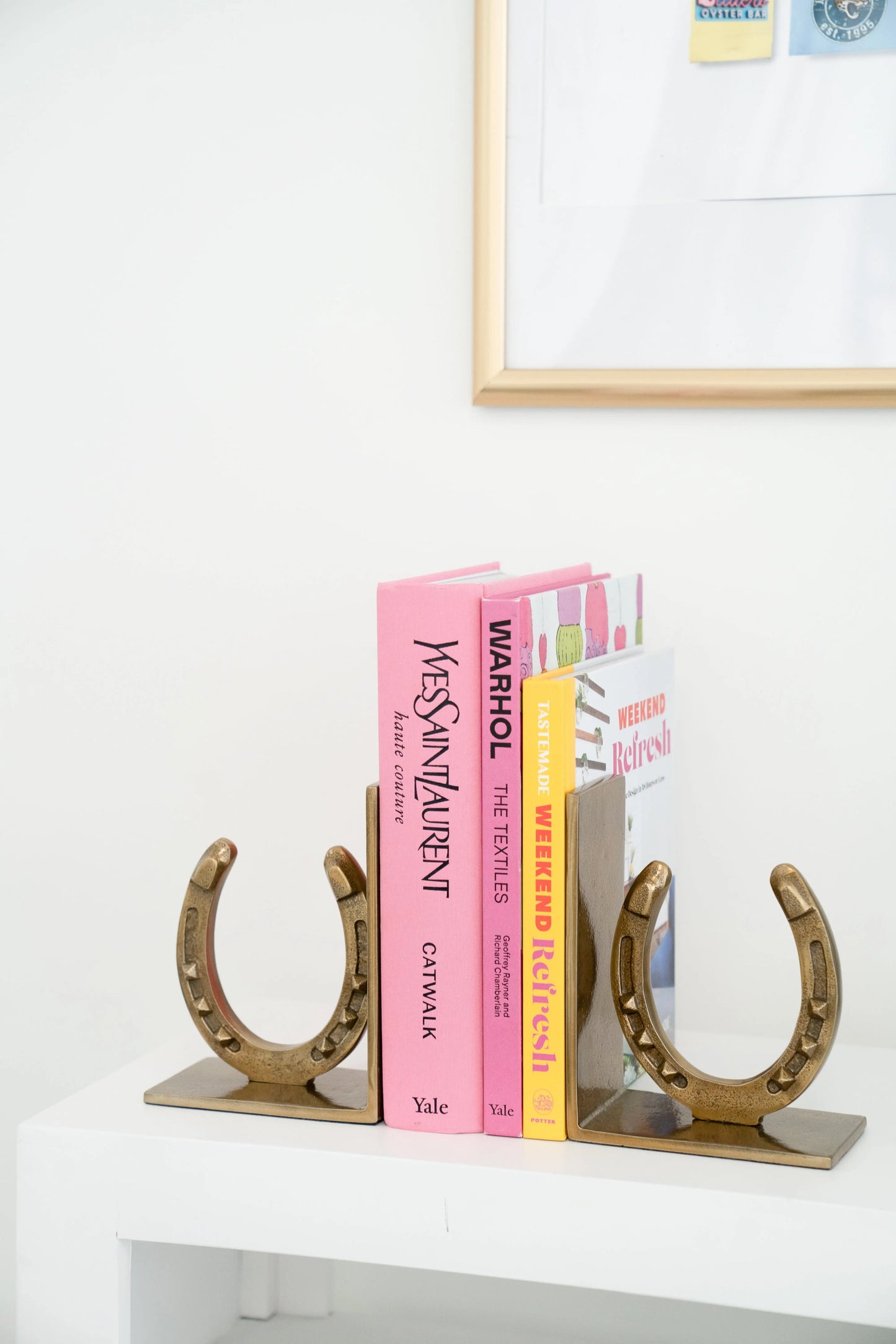 Horseshoe-shaped bookends holding books on a white surface.