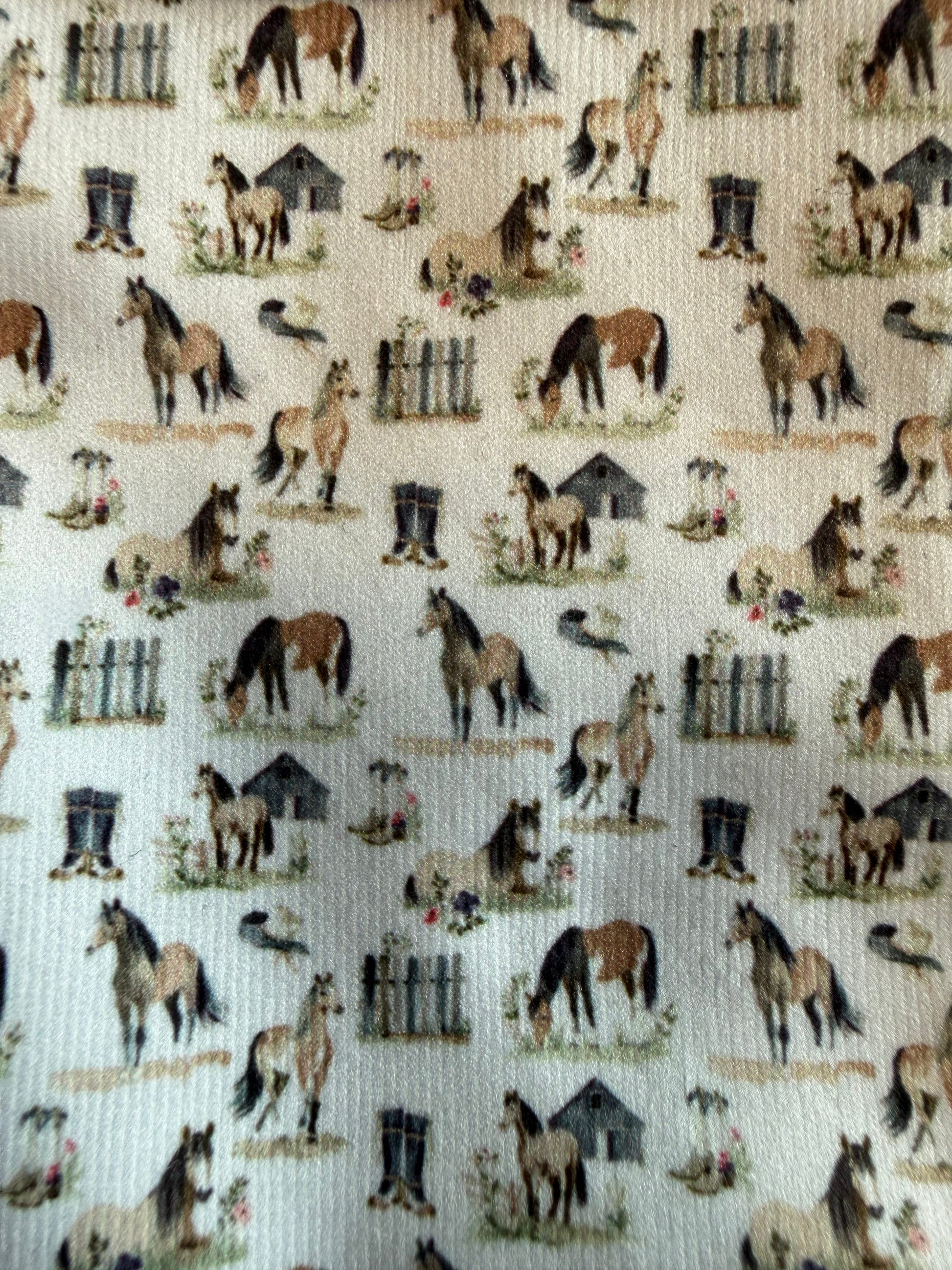 Pattern of horses, boots, and fences on a beige background