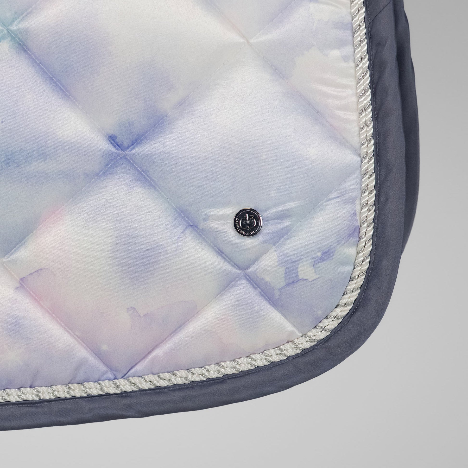 Quilted saddle pad with a button on a gray background